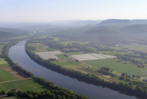 A bird's eye view of fthe Connecticut River and farmland in Sunderland on a sunny summer day